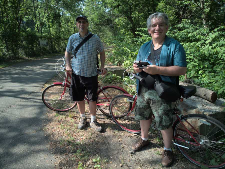 Tim and Wilbur standing next to two red bicycles.